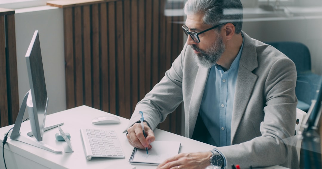 IT compliance professional at a desk reviewing SOC 2 audit readiness documents and ISO 27001 control checklists